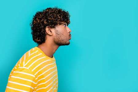 Profile portrait of carefree african guy pouted cheeks hold breath look empty space isolated on turquoise color backgroundの写真素材