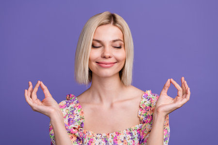 Photo of adorable sweet woman dressed flower print blouse closed eyes enjoying yoga isolated purple color backgroundの写真素材
