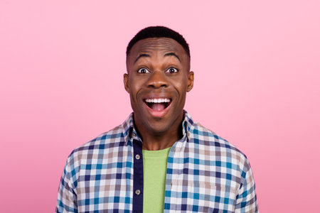 Photo of young guy impressed reaction wearing plaid shirt surprise for birthday party made by his friends isolated on pink color backgroundの写真素材