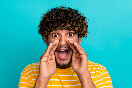 Photo portrait of nice young male excited share secret dressed stylish striped yellow garment isolated on cyan color backgroundの写真素材