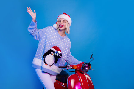 Photo of cheerful cute girl wear trendy ornament clothes presenting empty space novelty offer isolated on blue color neon light backgroundの写真素材