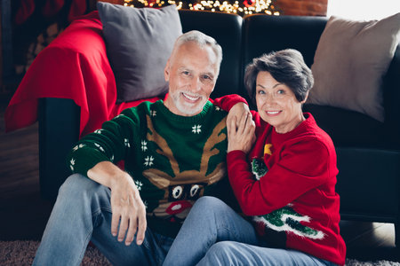 Photo of two idyllic aged soulmates sit floor cuddle embrace enjoy christmastime fairy house indoorsの写真素材