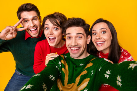 Photo of positive cheerful best buddies recording selfie video on christmas event make v sign isolated bright color backgroundの写真素材