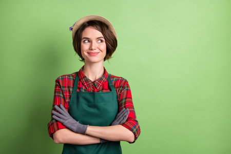 Photo of pretty positive lady crossed arms look interested empty space isolated on green color backgroundの写真素材
