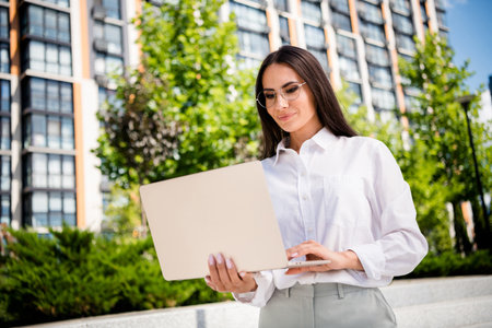 Photo of stunning professional lady brunette hair dressed stylish shirt writing sms message cityscape outsideの写真素材