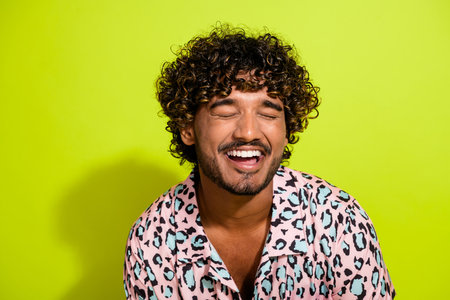Photo portrait of attractive young male closed eyes laughing wear trendy leopard print clothes isolated on yellow color backgroundの写真素材