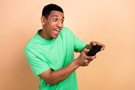Photo portrait of nice young male have fun playing a game console dressed stylish green outfit...