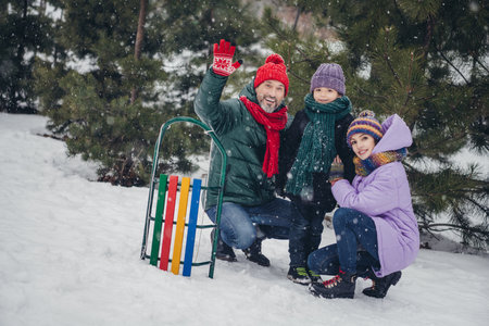 Photo of charming friendly husband wife small kids wear windbreakers waving arms hi together outside urban city parkの写真素材