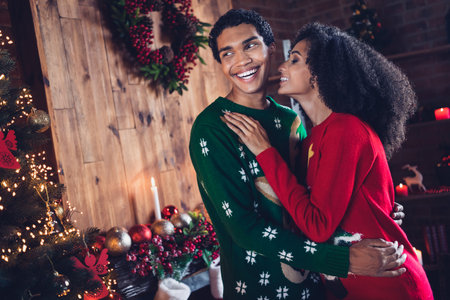 Photo of positive married couple lady guy hug embrace warmth celebrate new year indoors in decorated roomの写真素材