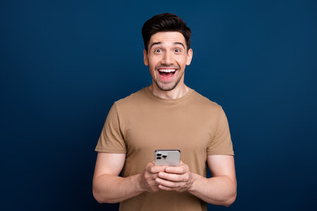 Photo of attractive cheerful man wear stylish clothes rejoice isolated on dark blue color backgroundの写真素材