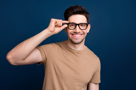 Photo of attractive nice man entrepreneur wear trendy clothes hold glasses recoemdn qualoty product isolated on dark blue color backgroundの写真素材