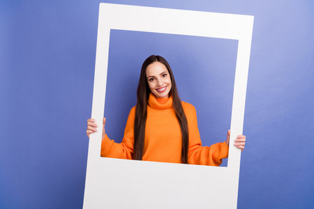 Photo of cheerful mature woman holding paper portrait zone frame with borders happy birthday party...