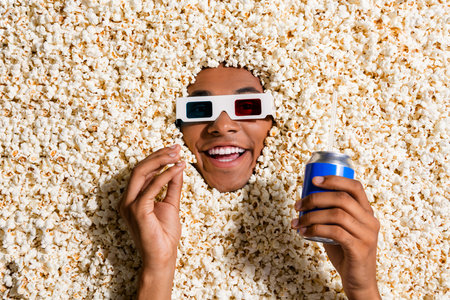 Photo of excited guy spend free time watch interesting movie prepare many pop corn drinks isolated backgroundの写真素材