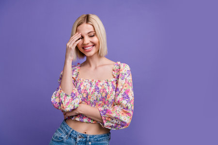 Photo of adorable positive girl hand touch face closed eyes toothy smile laughing empty space isolated on violet color backgroundの写真素材