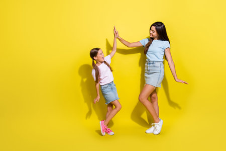 Photo of successful teen kid girls team win in school contest give high five isolated over bright color backgroundの写真素材