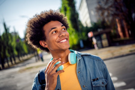 Photo of good mood thoughtful guy dressed jeans shirt headphones enjoying music outdoors urban city parkの写真素材