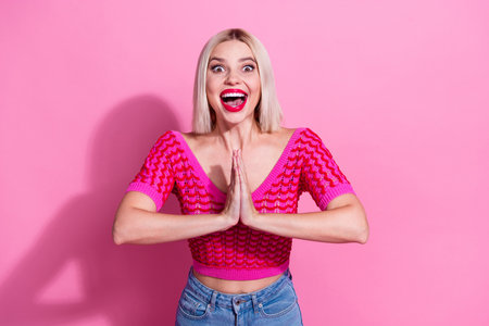 Portrait of astonished lovely person open mouth arms palms touch plead isolated on pink color backgroundの写真素材