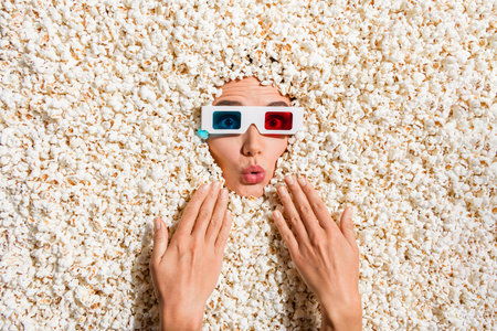 Above view photo of impressed person watch movie 3d glasses pouted lips hands face buried in popcorn backgroundの写真素材