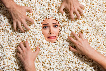 High view portrait of crazy worried lady scared zombie people arms face buried inside popcorn backgroundの写真素材