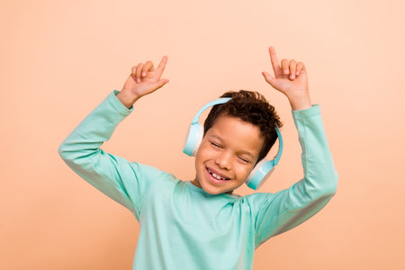 Photo of funky carefree glad boy wear trendy turquoise clothes have fun hands showing empty space...