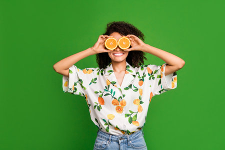Photo of funky sweet lady wear print shirt making citrus halves glasses empty space isolated green color backgroundの写真素材