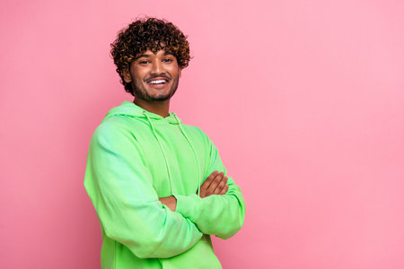 Full size photo of cheerful hipster green sweatshirt sports wear brand model smiling and folded hands isolated on pink color backgroundの写真素材