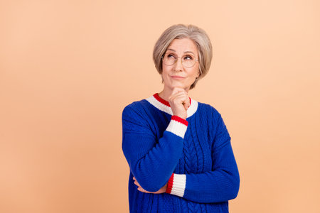 Portrait of charming minded lady wearing trendy blue clothes looking up hmm offer empty space...