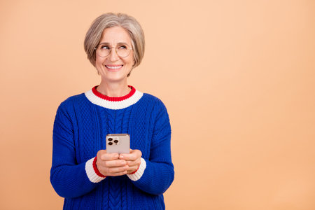 Photo of charming cheerful woman wear stylish clothes thinking buy novelty apple ipone look empty...
