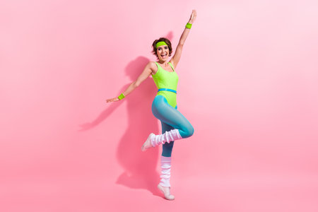 Full length portrait of positive overjoyed charming person stand one leg raise arms rejoice isolated...