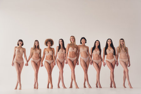 No retouch photo of feminists girls feel confidence about imperfect natural body hold hands isolated pastel color backgroundの写真素材