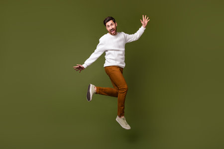 Full length photo of crazy carefree guy running store seasonal sale isolated on khaki color...