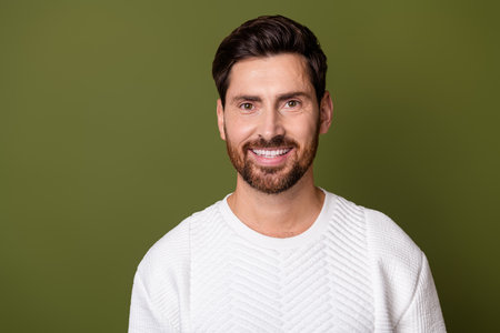 Photo of positive nice man beaming bright smile wear fashionable clothes empty space isolated on khaki color backgroundの写真素材