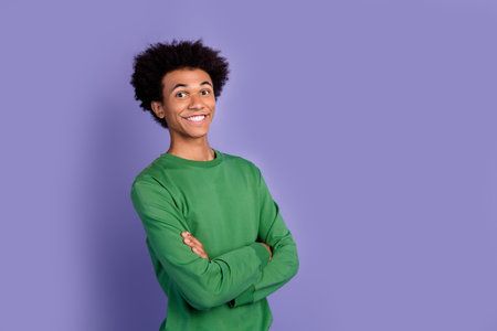 Photo of cheerful good mood guy wear green pullover arms folded empty space isolated purple color backgroundの写真素材