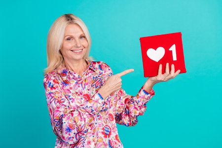 Photo of shiny cute woman dressed print shirt pointing finger heart like card isolated turquoise...