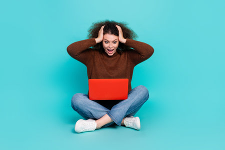 Full body photo of attractive young woman sit floor netbook shocked dressed stylish brown clothes...