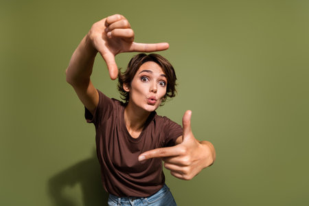 Photo portrait of attractive woman shocked hands frame gesture wear trendy brown clothes isolated on khaki color backgroundの写真素材