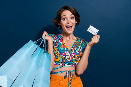 Photo of lovely young lady excited shopping bags credit card wear trendy flared pants garment...