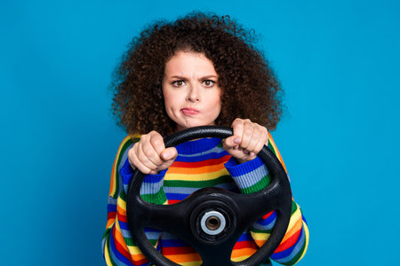 Photo portrait of lovely young lady drive car annoyed face nervous dressed stylish rainbow print garment isolated on blue color backgroundの写真素材