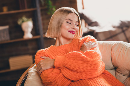 Photo of lovely gorgeous person sit comfy chair closed eyes arms embrace shoulders calmness weekend morning house indoorsの写真素材
