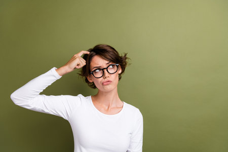 Photo portrait of lovely young lady scratch hand look skeptical empty space wear trendy white...