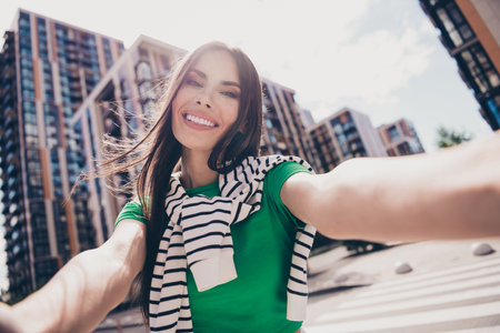 Portrait of young girl recording selfie video showing her favorite city center demonstrating outdoors sightseeing adventures in kyivの写真素材