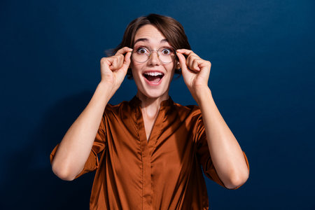 Photo portrait of attractive young woman touch specs excited reaction dressed stylish brown blouse...
