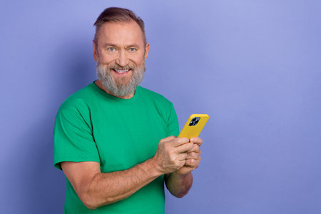 Portrait of cheerful friendly person hands hold smart phone chatting empty space isolated on purple...