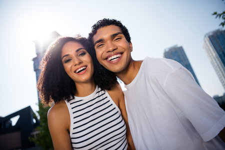 Photo of cheerful excited wife husband wear casual clothes embracing laughing together outside urban city streetの写真素材