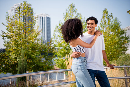 Photo of charming pretty wife husband wear casual clothes embracing enjoying river bank view outside urban city streetの写真素材