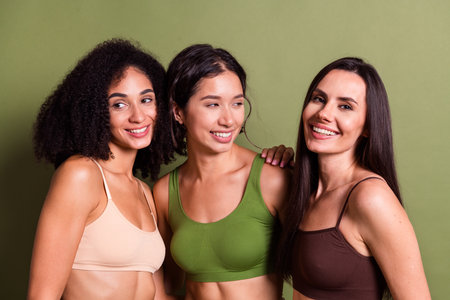 Studio photo of slim adorable women wear lingerie no retouch skin cuddling isolated pastel khaki color backgroundの写真素材