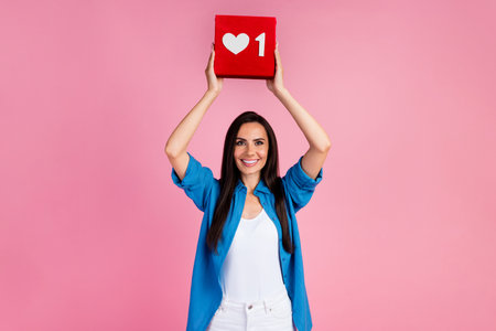 Portrait of lovely satisfied cute woman wear stylish shirt arms holding social media like over head...