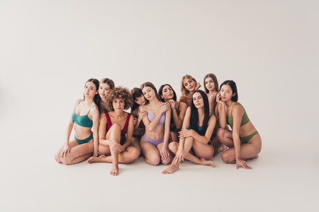 Full length no filter studio photo of tender pretty women underwear cuddling loving body positive isolated beige color wall backgroundの写真素材