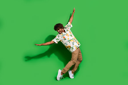 Full length photo of funky cheerful latin guy dressed print shirt dancing disco isolated green color...