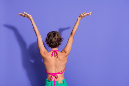 Back view photo of adorable happy young woman raise arms celebrate rejoice summer vacation empty...
